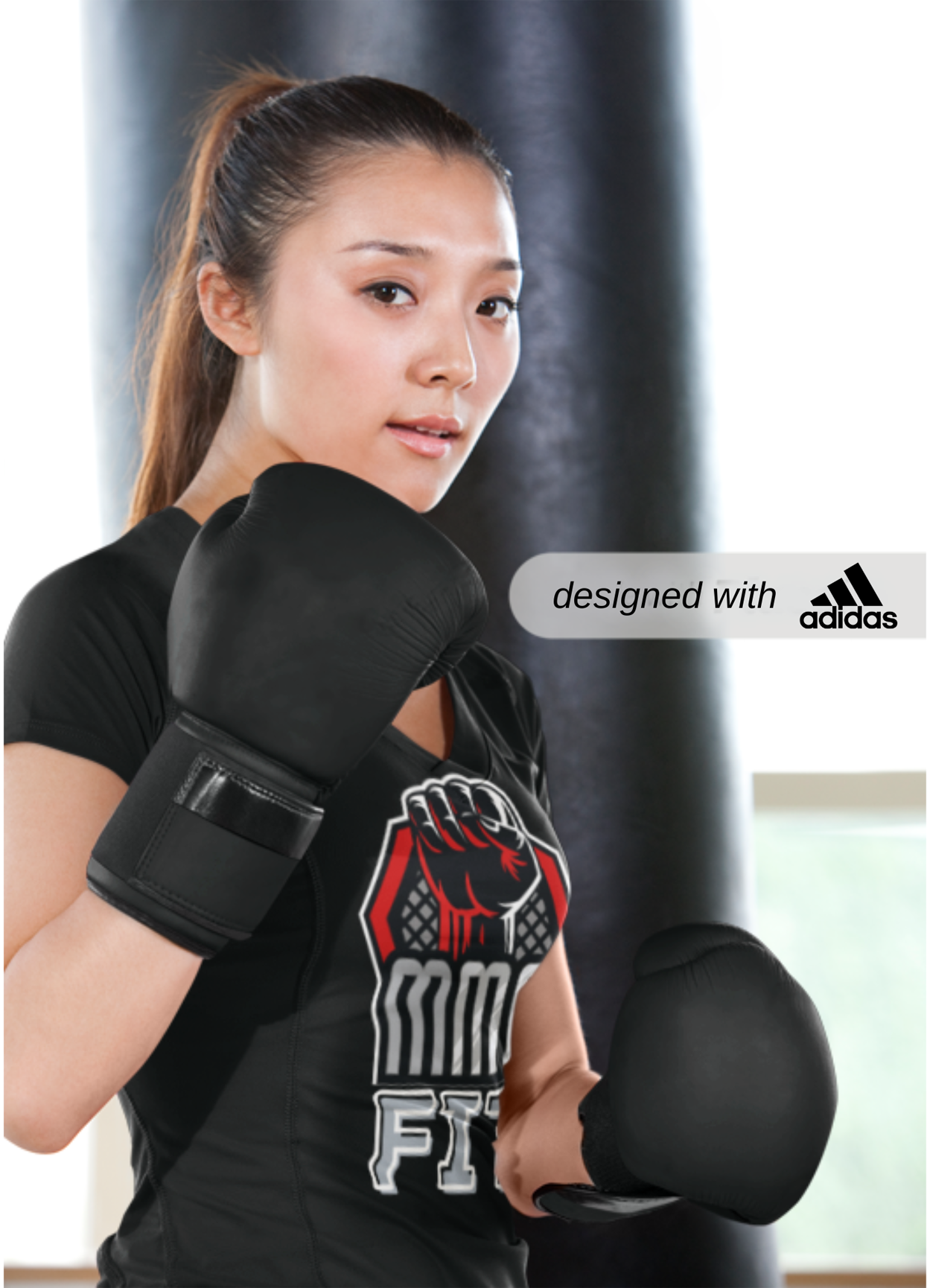 Adidas Sports T-shirt for MMA Fans, MMA MOTIF T-SHIRT, Woman wearing black boxing gloves and a black t-shirt with a logo, standing in front of a punching bag. Adidas logo visible.