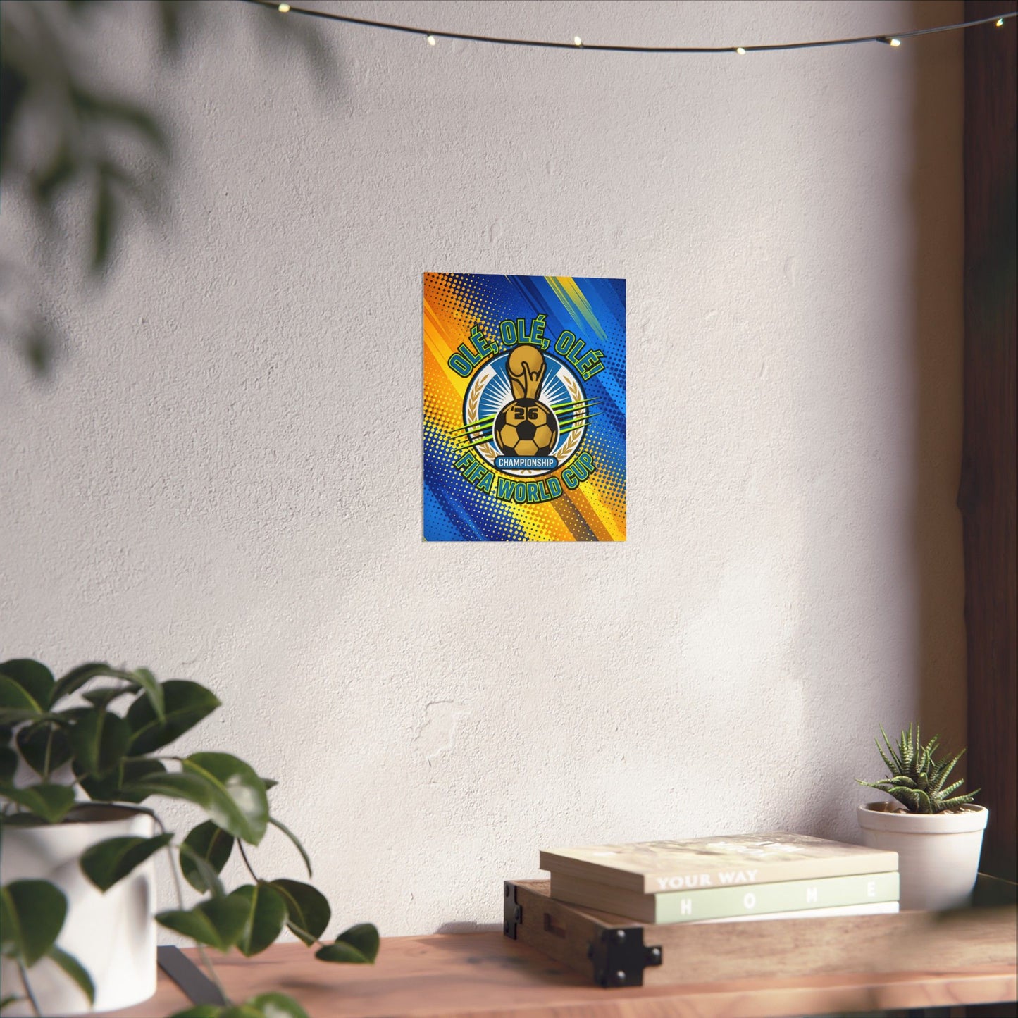 Colorful poster on a white wall with plants and books on a table below.
